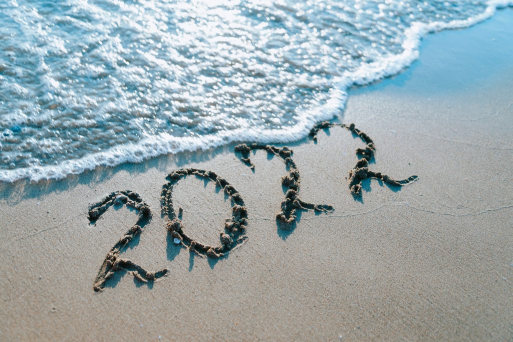 Inscription 2022 on sand by the sea