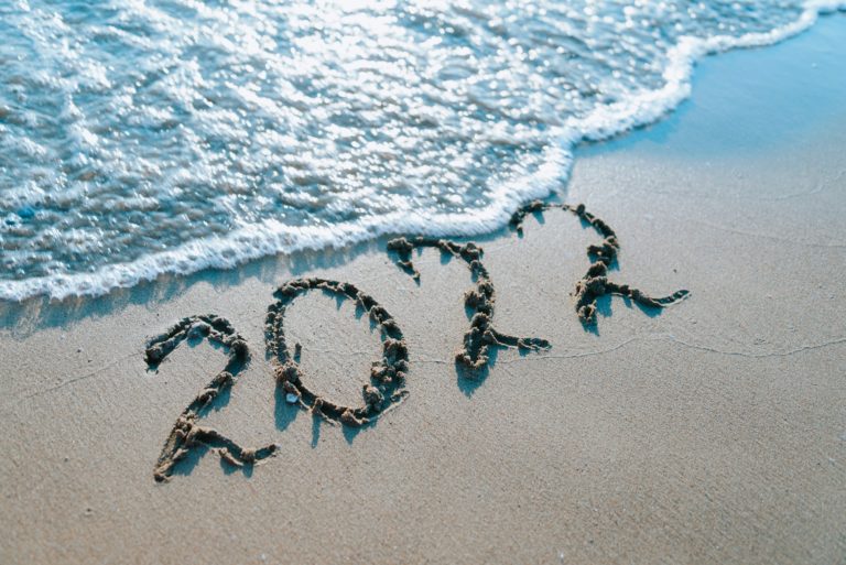 Inscription 2022 on sand by the sea