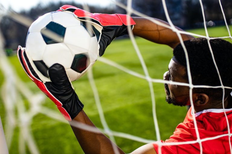 brazilian man goalkeeper catches the ball in the stadium during a football training